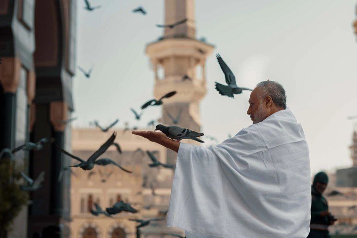 A pilgrim in Ihram in quiet reflection, representing Umrah performed on behalf of a loved one